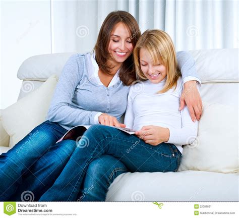 Mother With Teenage Daughter Reading Magazine Stock Image