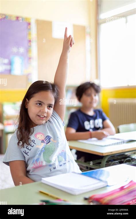 Portrait Of Little Caucasian Girl With Raised Hand In Class Primary