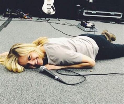 A Woman Laying On The Ground With A Microphone In Front Of Her And An