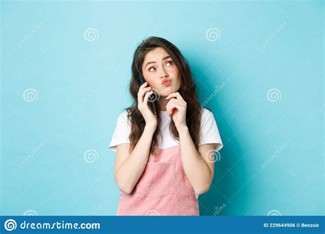 cute thoughtful girl talking on smartphone and thinking making choice order delivery standing