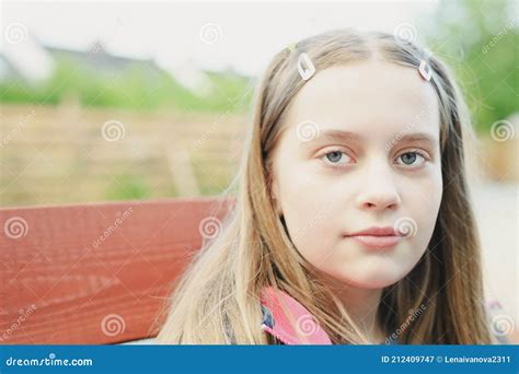 Outdoor Portrait Of Cute Blonde Hair Teenage Girl Looking At Camera