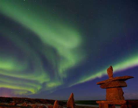 Northern Lights Aurora Borealis Above An Inukshuk In The Town Of