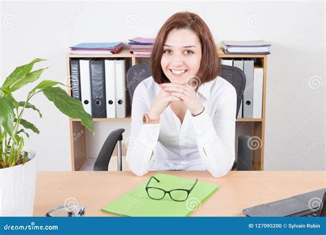 Smiling Young Woman Sitting At Her Desk In Office Stock Photo Image