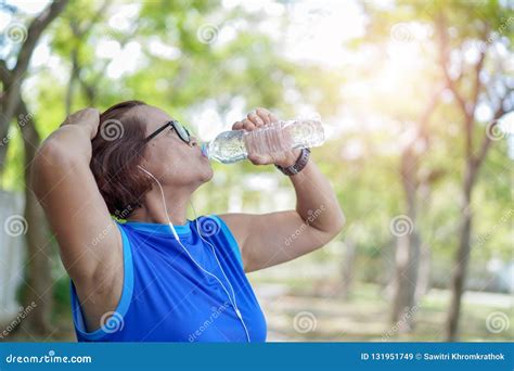 Senior Asian Woman Drinking Water Bottle After Work Out Exercising