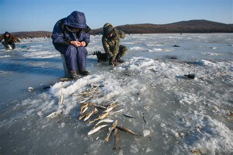 Men Sit On The Ice And Fish Winter Fishing In Russia Editorial Photo