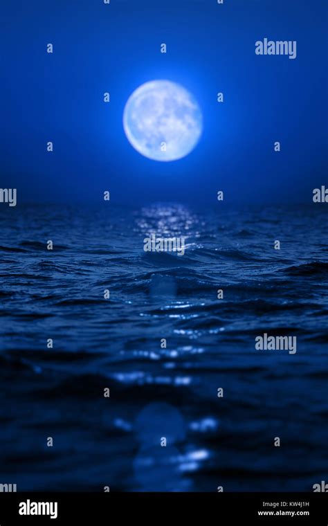 Full Moon Rising Over Empty Ocean At Night Stock Photo Alamy