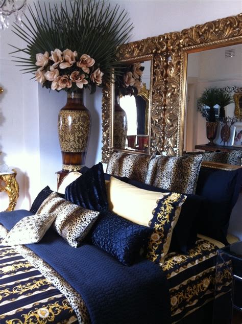 This bed is resting on top of a very elegant dark brown colored hardwood floor. Navy blue, gold, white bedroom | Bedroom | Pinterest