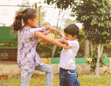 Two Little Siblings Fighting With Each Other At Park Kids Hitting And