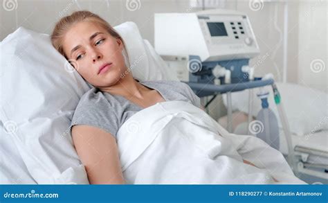 A Sick Young Woman Lying In A Hospital Bed And Waiting A Doctor Stock