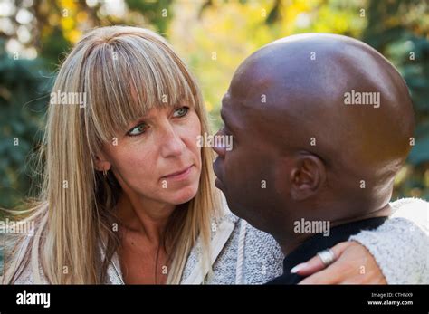 interracial married couple having a deep conversation in a park edmonton alberta canada stock