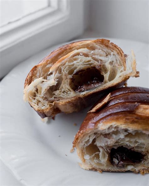 Two Pastries On A White Plate With A Window In The Backgroung