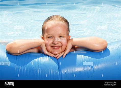 Los Niños Se Bañan En La Piscina La Niña Sonríe Y Mira A La Cámara Apoyada En Un Borde