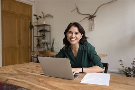 Joyful Businesswoman Sits At Workplace With Laptop At Home Office Stock