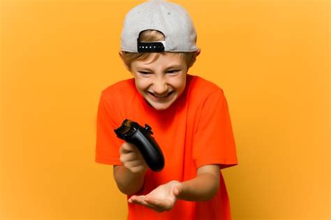 Premium Photo A Child Gamer Holds A Gamepad In His Hands And Shows