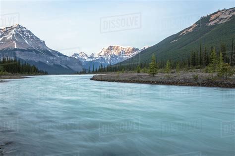 The Blue Waters Of The Bow River Cut Through The Snowy Canadian Rockies