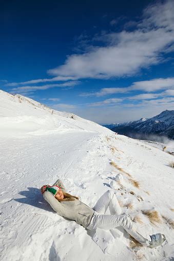 Women Snow Skier Sunbathing Lying On The Ground Enjoying On Sunny Ski