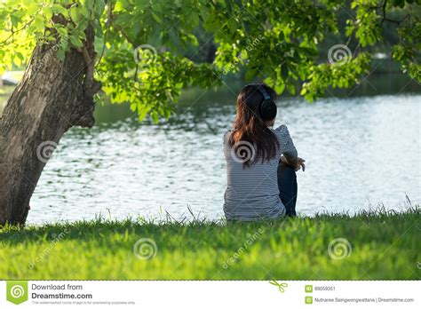 Young Woman Sitting On River Bank Under Tree On Head Her Wear He Stock