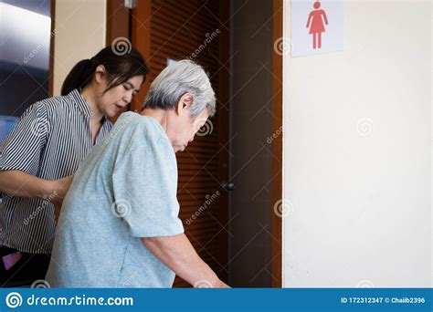 Female Caregiver Is Helping Support Elderly Woman Walk Into The Restroom Carefully Asian Senior