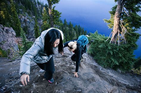 Two Female Climbing A Steep Hill At Crater Lake By Edwoodya