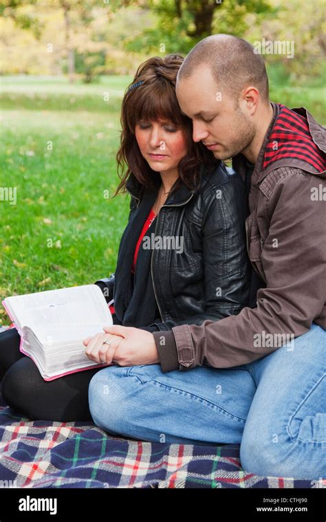Couple Reading Bible And Praying Together In The Park Edmonton