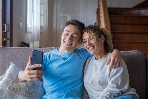 Smiling Middle Aged 40s Mother Rest With Grown Up Son Using Smartphone