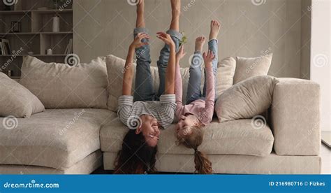 Joyful Mom And Little Daughter Lying Upside Down On Sofa Stock Footage