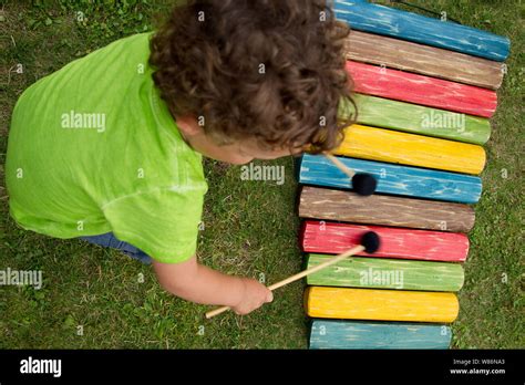 Music Learning By A Child Young Boy Playing The Xylophone In A Garden