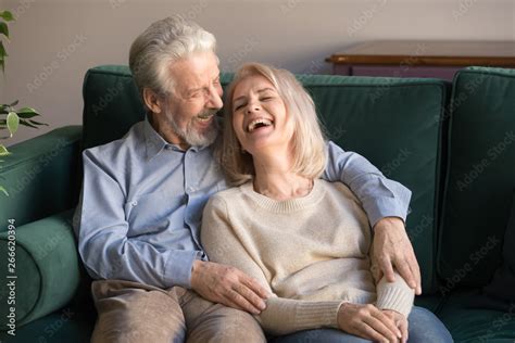 Loving Middle Aged Husband Embracing Laughing Wife Sitting On Couch Stock Photo Adobe Stock