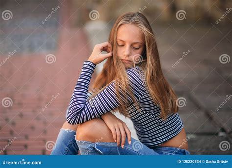 Young Teenage Poses To Photographer Blonde Girl In Jeans And Blouse