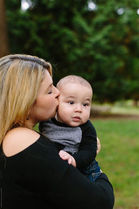 Beautiful Mother Kissing Baby Son On Cheek By Stocksy Contributor