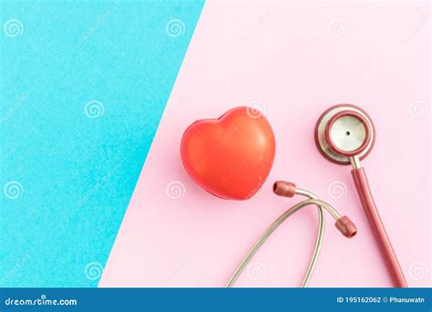 Top View Red Stethoscope And Red Heart Shape On Pink And Blue Stock