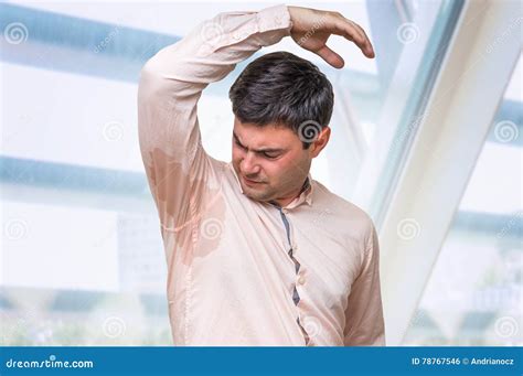 Man With Hyperhidrosis Sweating Under Armpit In Office Stock Photo