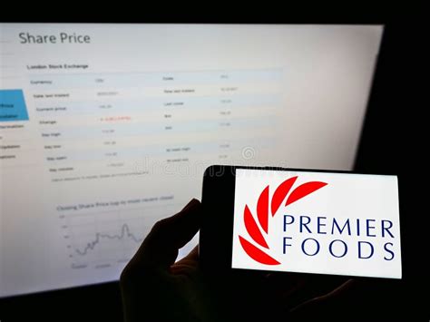 Person Holding Cellphone With Logo Of British Food Manufacturer Premier