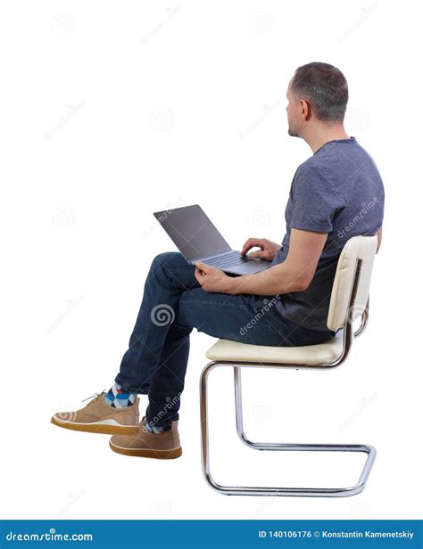 Side View Of A Man Who Sits On A Chair With A Laptop Stock Photo