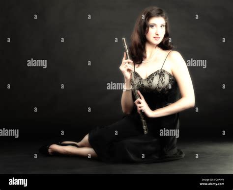 Girl Woman Plays The Flute On A Black Background Stock Photo Alamy