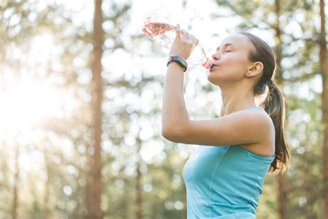Woman Drinking Water After Work Out Exercising On Sunset Evening Stock