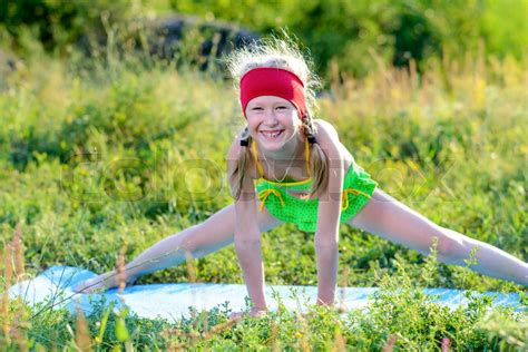 Happy Girl Stretching Her Legs On Mat On Grasses Stock Image Colourbox