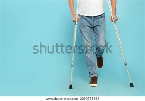 6 Teenage Boy Injured Leg Using Crutches On Turquoise Background Images