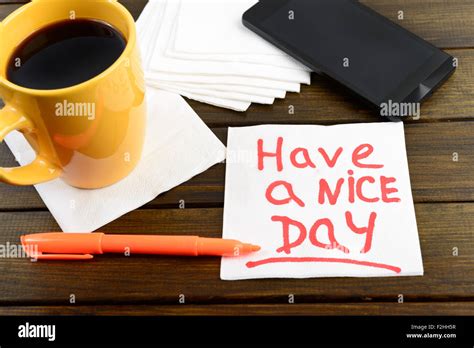 Have A Nice Day Writing On White Napkin Around Coffee Pen And Phone On