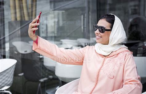 Moroccan Woman With Hijab And Typical Arabic Dress Taking Selfie In Cafe — Female Reflection