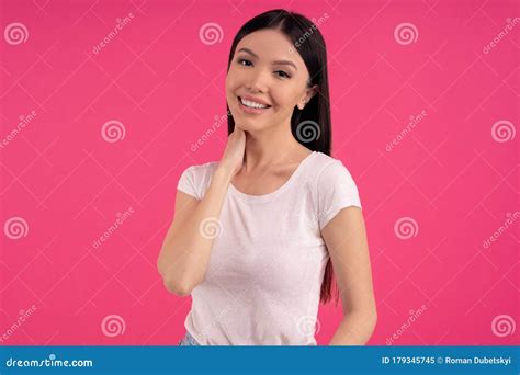 Portrait Of Feminine Girl With Pleasant Smile Gentle Look Touches Neck Has Delighted Face