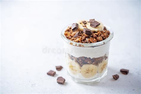 Chocolate And Banana Greek Yogurt Granola Parfait In A Glass Stock