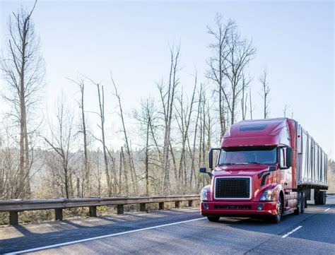 Bright Red Big Rig Bonnet Semi Truck Transporting Cargo In Semi Trailer