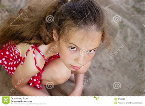 Beautiful Sad Little Girl Is Looking With Serious Face At Camera Stock