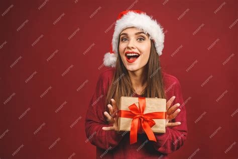 Premium Photo Excited Surprised Woman In Red Santa Claus Outfit Holding Present