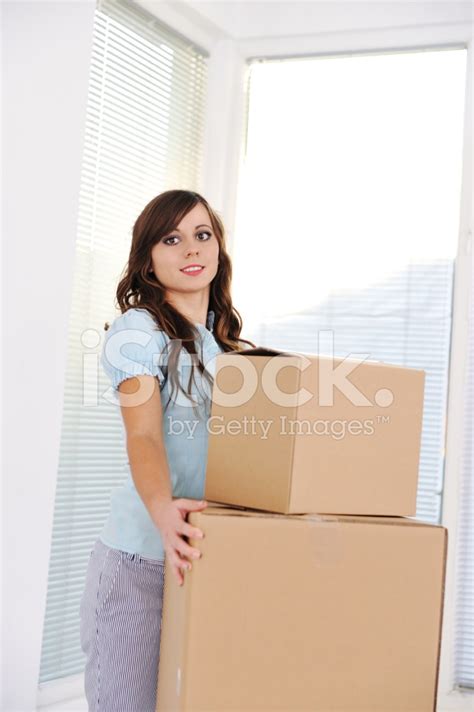 Young Woman Lifting A Heavy Cardboard Moving Box Stock Photo Royalty