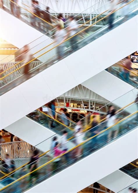 People On Fast Moving Escalators In Modern Shopping Mall Stock Image