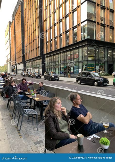 london city with restaurants table on the sidewalk to help the hospitality industry recover from