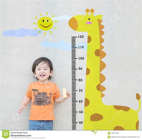 Closeup Happy Asian Kid Stand For Measure Height With Cute Cartoon At