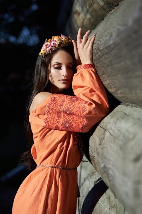 Beautiful Slavic Woman In An Orange Ethnic Dress And A Wreath Of